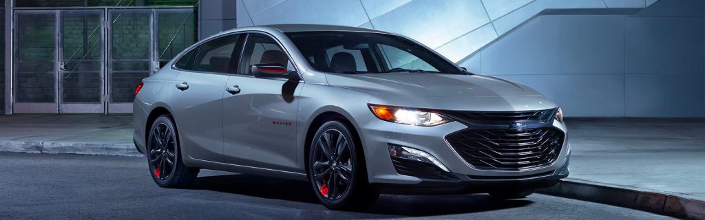 2025 Chevy Malibu parked in front of a building at night